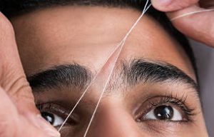 Facial hair removal eyebrows threading procedure in beauty salon